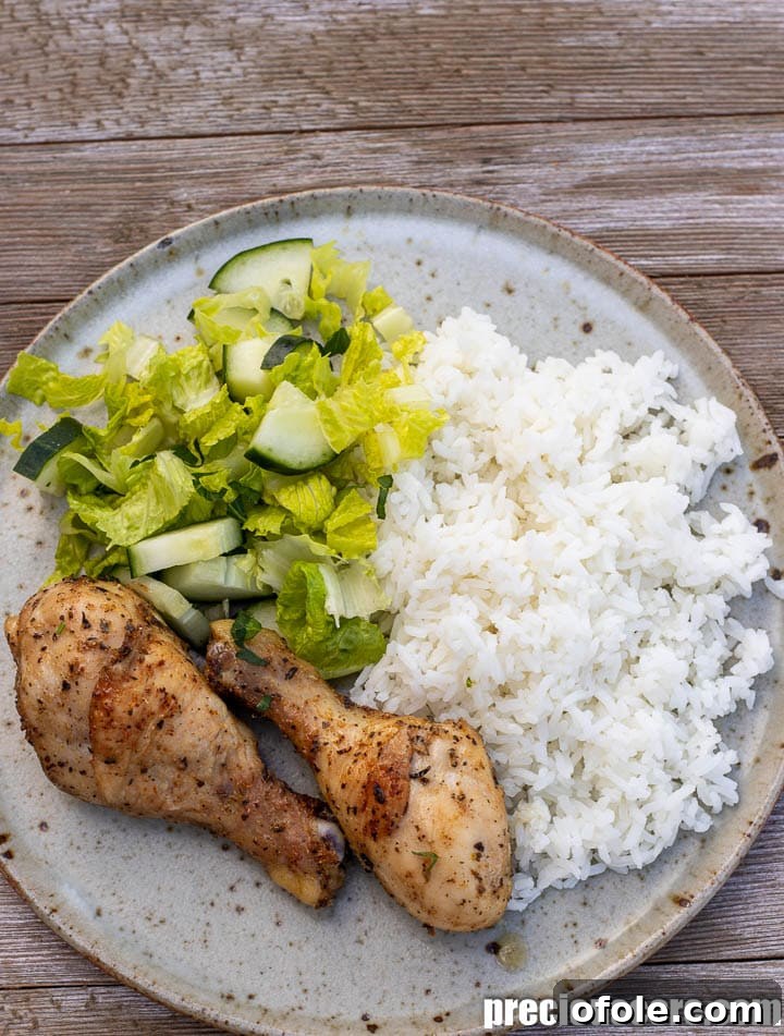 Extra Crispy Oven Baked Chicken Drumsticks 4 Chicken drumsticks, rice, and fresh lettuce arranged on a dinner plate.
