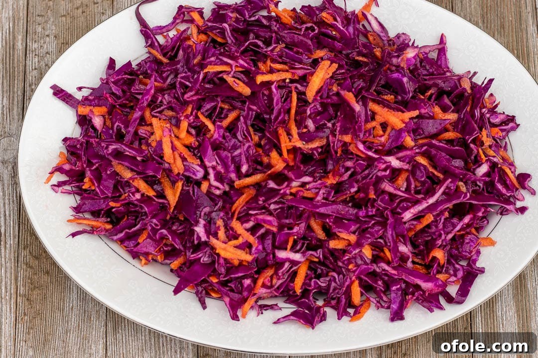 Close-up of vibrant cabbage slaw on a serving platter, highlighting the shredded carrots