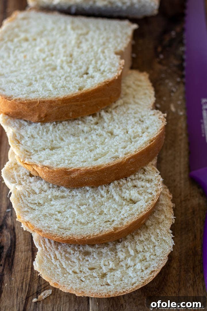 Slices of homemade sandwich white bread on a chopping board, highlighting its soft texture.