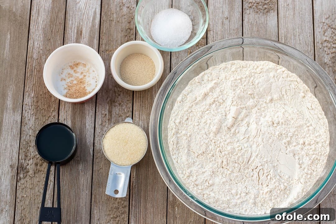 Bowls and measuring cups containing the essential ingredients for Easy Sandwich Bread Recipe.