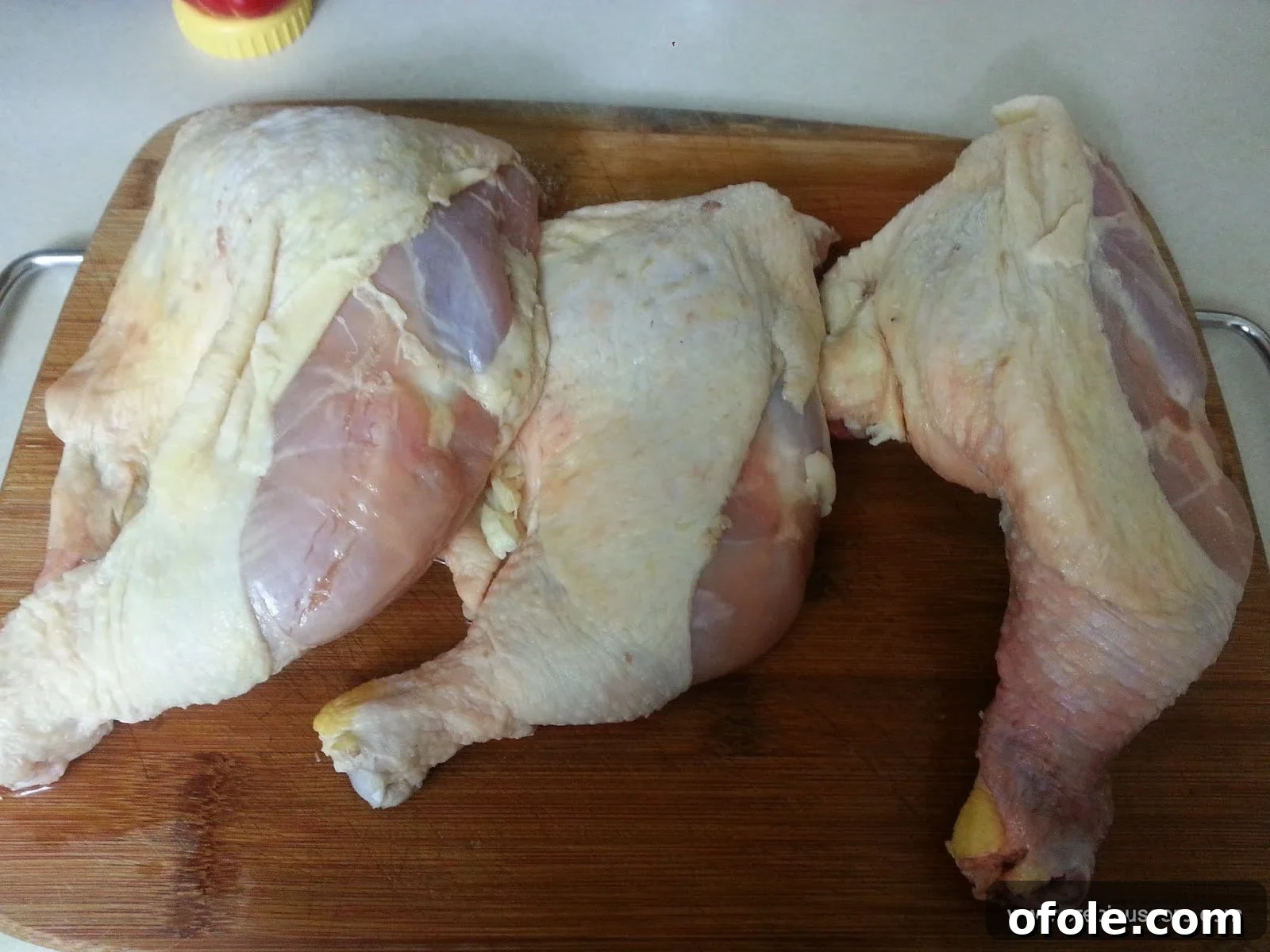 A live chicken in a coop, symbolizing the fresh origins of the dish.