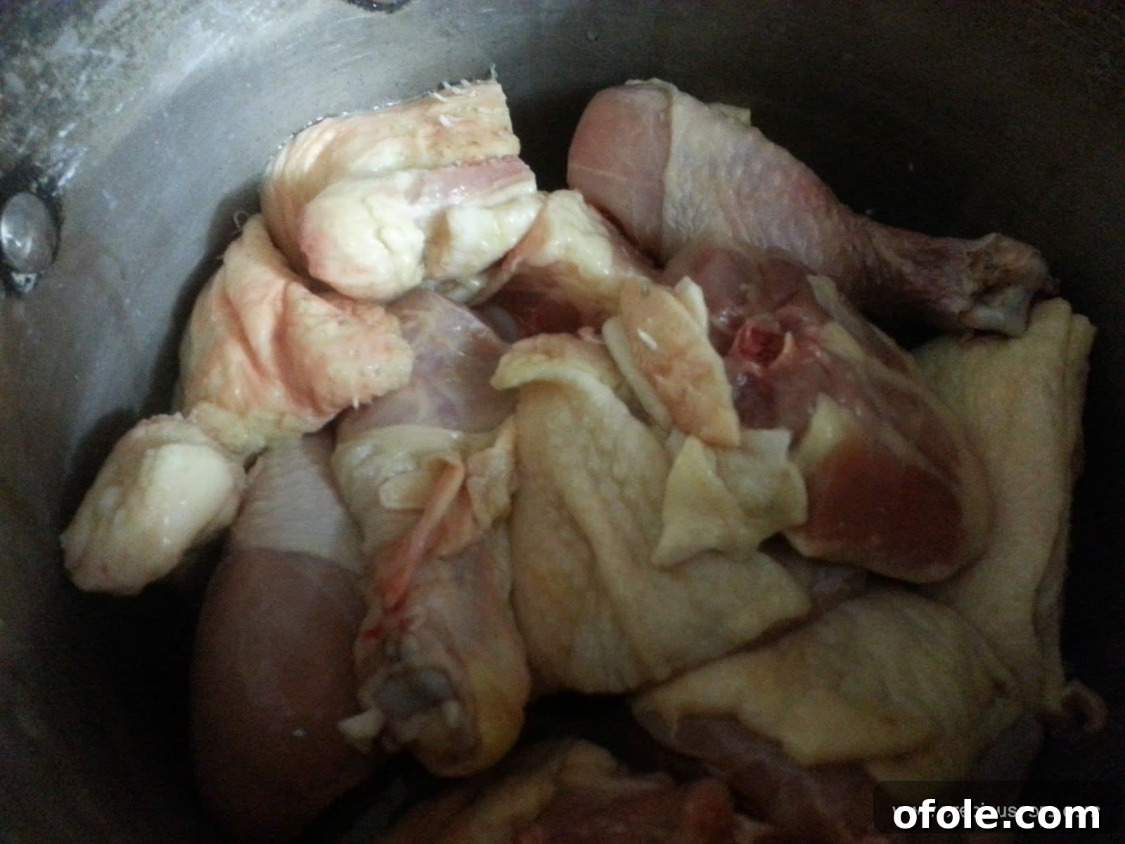 Cleaned and cut chicken pieces neatly arranged in a cooking pot.
