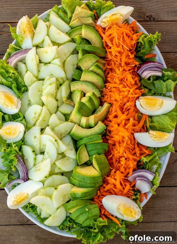 Crisp Green Salad 2 A vibrant platter featuring fresh lettuce, sliced cucumbers, and an array of other colorful vegetables, ready to be tossed into a healthy salad.