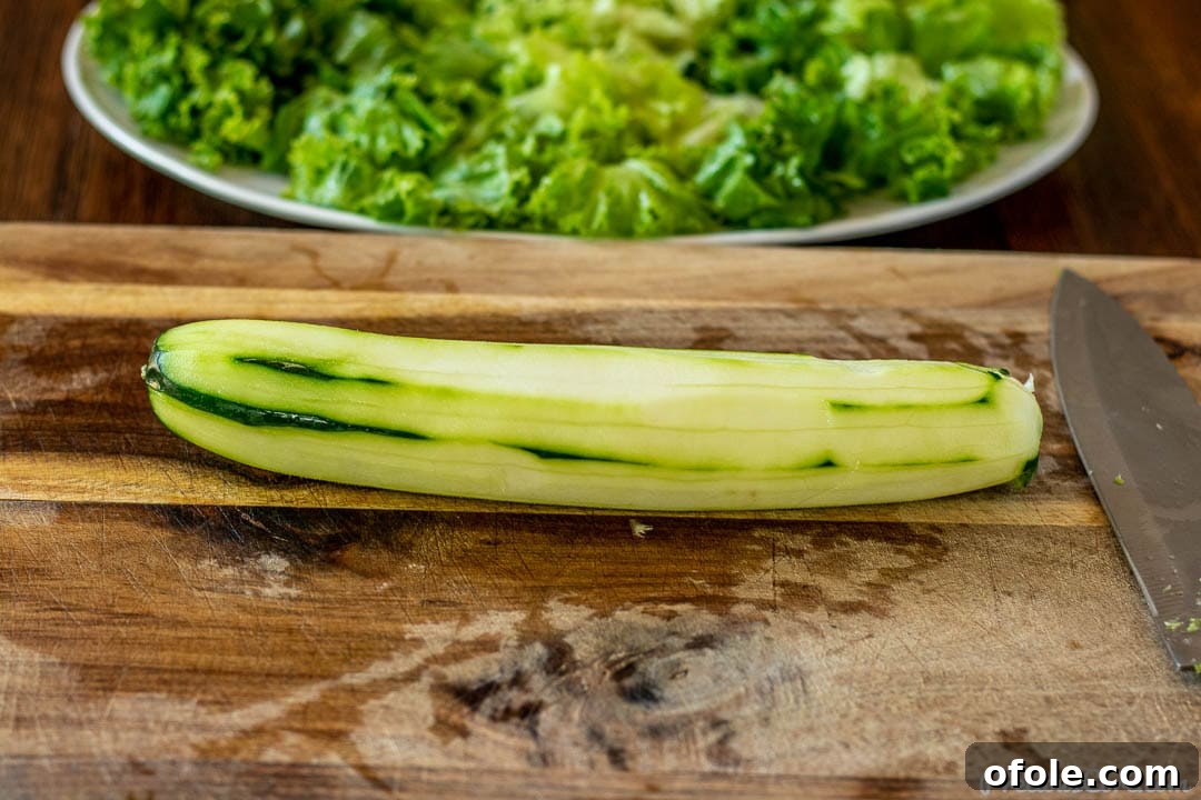 Crisp Green Salad 4 A freshly peeled garden cucumber resting on a wooden chopping board, ready to be sliced for a crisp salad.