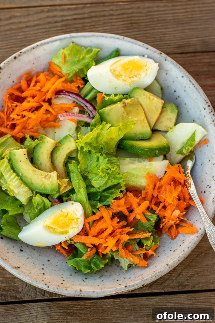 Crisp Green Salad 8 A delectable serving of fresh lettuce salad in a bowl, generously drizzled with a bright lemon dressing, showcasing its vibrant ingredients.
