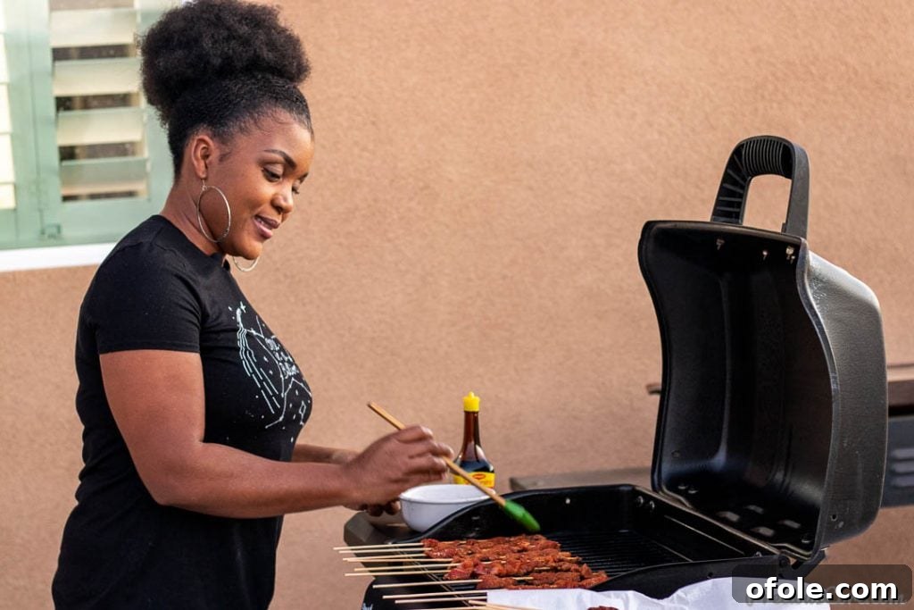 Authentic Cameroonian street food: Woman grilling marinated beef soya