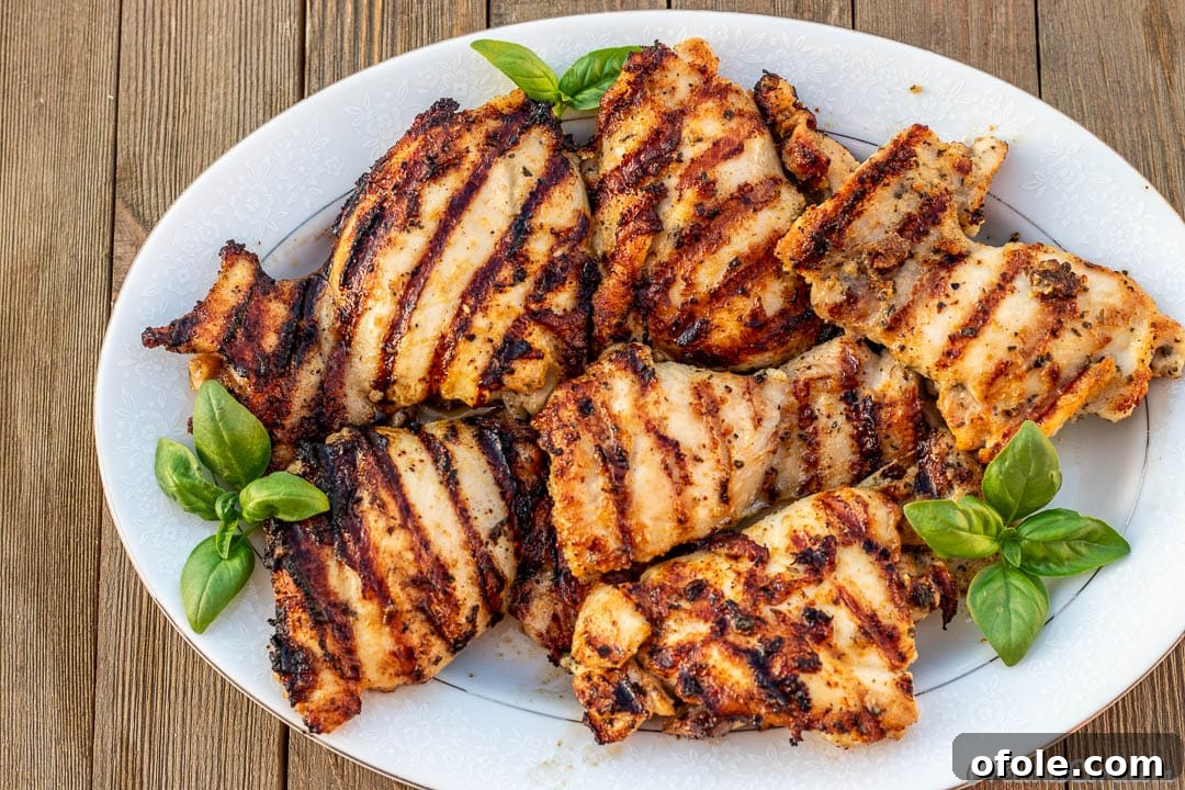 Succulent Grilled Boneless Chicken Thighs 6 Platter of grilled chicken thighs with grill marks.