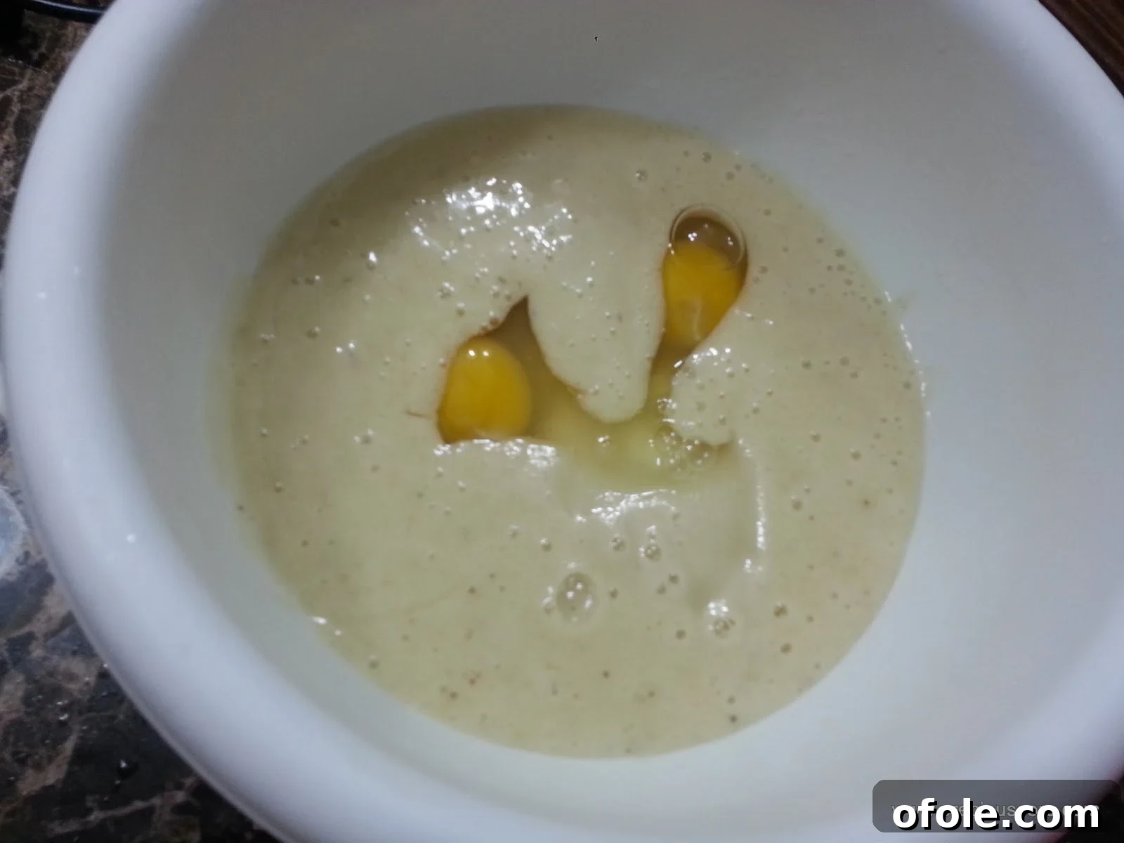 Eggs added to the banana mixture in a mixing bowl.