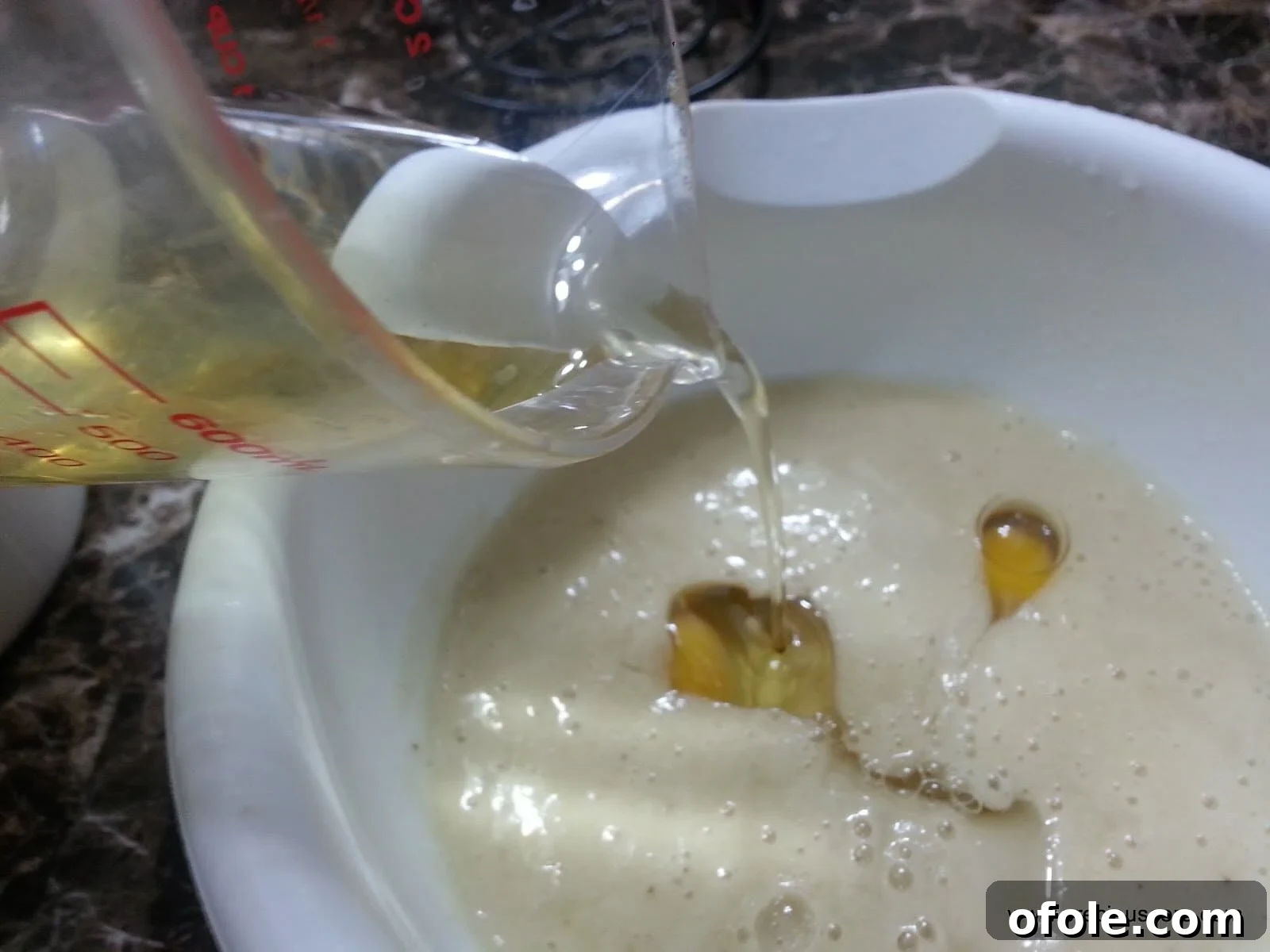 Vegetable oil being poured into the wet ingredients.
