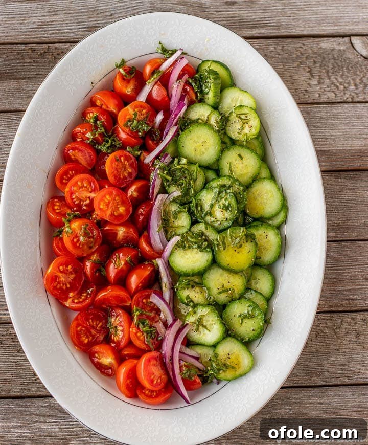 Zesty Cucumber Tomato Onion Medley 2 Vibrant Cucumber Tomato Onion Salad beautifully arranged on a platter, ready to be served.