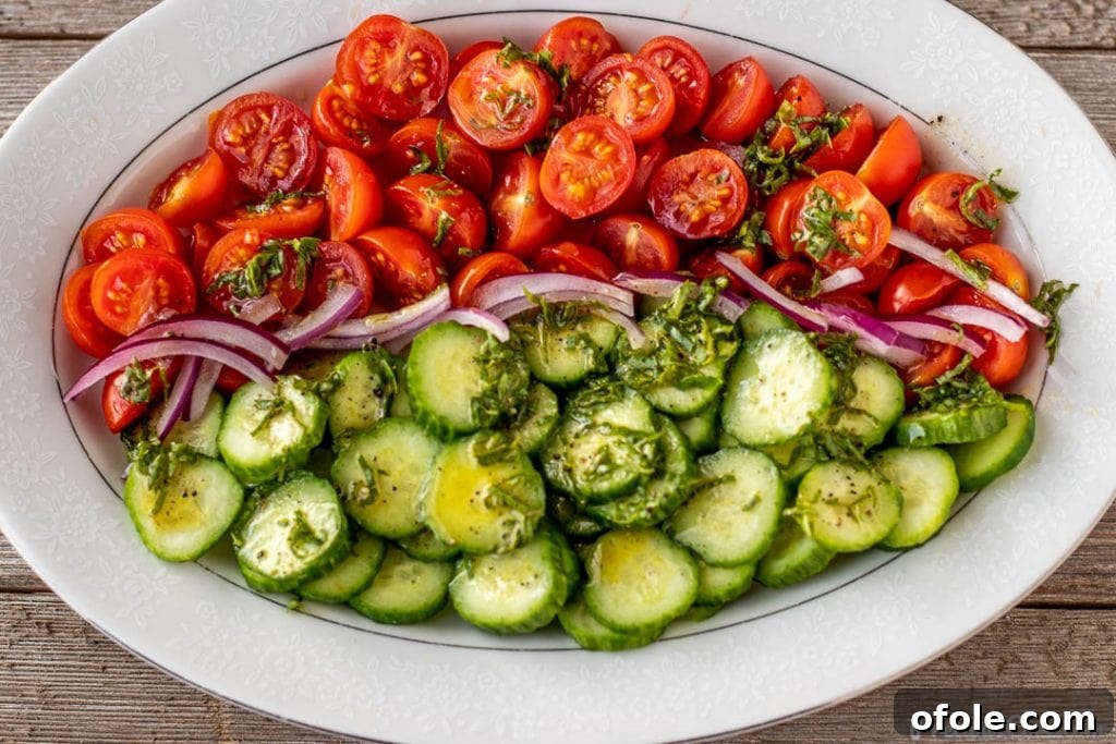 Zesty Cucumber Tomato Onion Medley 6 Cucumber tomato onion salad with the basil lemon dressing drizzled over it.