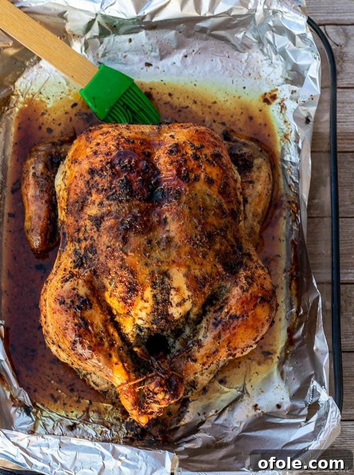 Savory Herb Roasted Chicken 7 Golden brown roast chicken in baking dish, hot out of the oven, ready to rest.