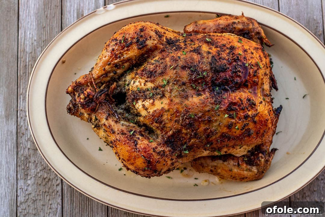 Savory Herb Roasted Chicken 8 Beautifully presented roast chicken on a platter, ready to be carved and served.