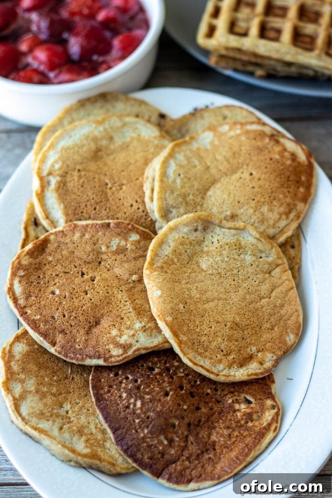 A stack of perfectly cooked plantain pancakes resting on a serving platter, ready to be enjoyed.