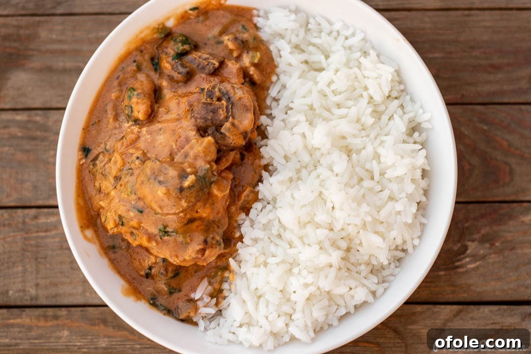 Soulful African Peanut Chicken Stew 3 Landscape picture of chicken peanut stew with a side of white rice.