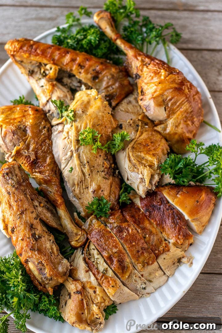 A beautifully arranged platter of perfectly carved herb roasted turkey, garnished with fresh herbs, ready for the dining table.