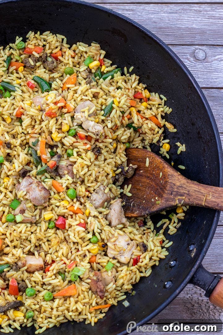 Close-up of Chicken Fried Rice being stir-fried in a wok, highlighting the vibrant vegetables and perfectly cooked rice