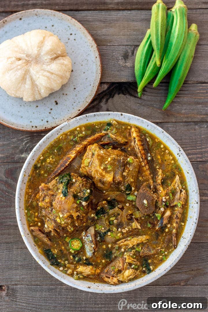 A bowl of African Okra Soup with a plate of Garri fufuf on the side