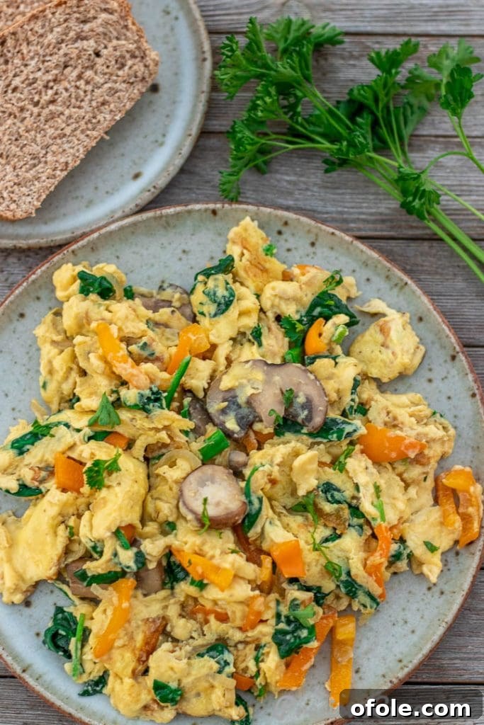 Vibrant Veggie Scramble 4 A plate of scrambled eggs with vegetables, accompanied by whole wheat toast, ready for a balanced meal.