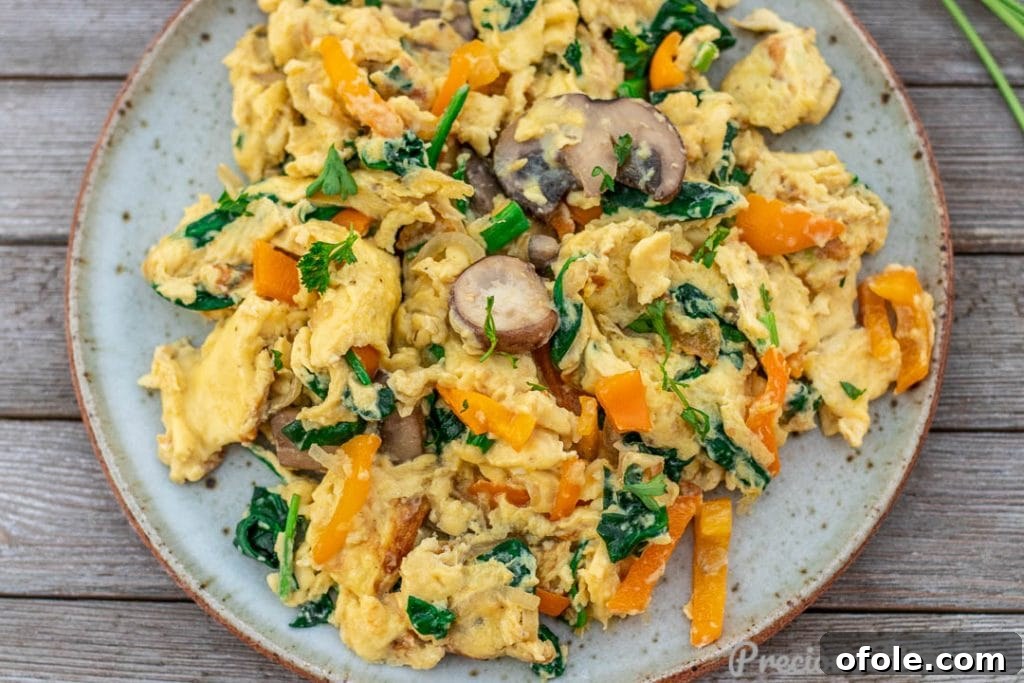 Vibrant Veggie Scramble 5 A landscape view of perfectly cooked scrambled eggs with a mix of colorful vegetables.