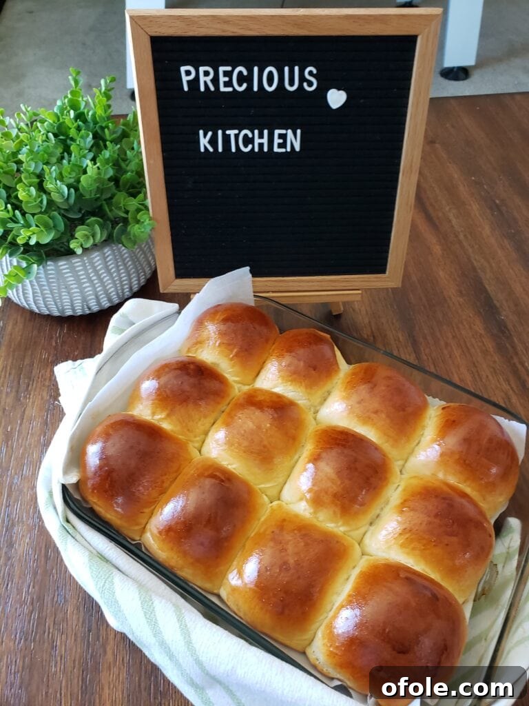 Introducing Our Little Miracle 7 Perfectly golden, fluffy dinner rolls cooling in a pan.
