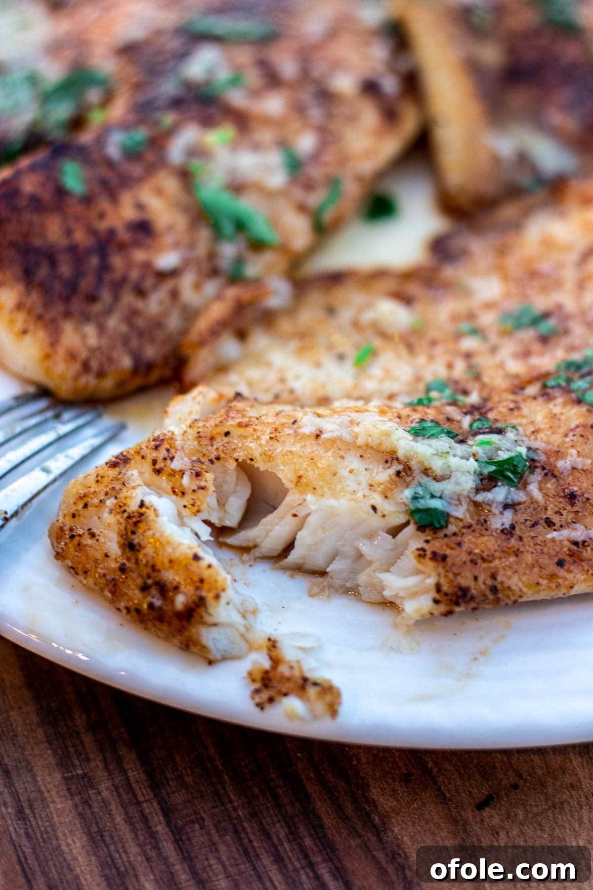 Close-up of flaky Lemon Butter Tilapia fish, showing its tender, juicy texture.