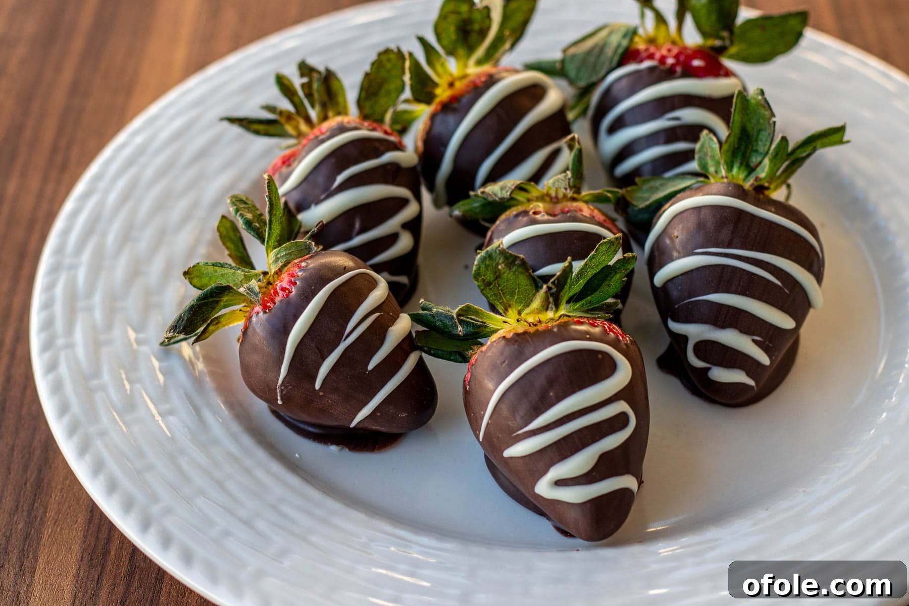 Effortless Chocolate Strawberry Indulgence 12 A generous serving of exquisitely prepared chocolate covered strawberries elegantly arranged on a plate.