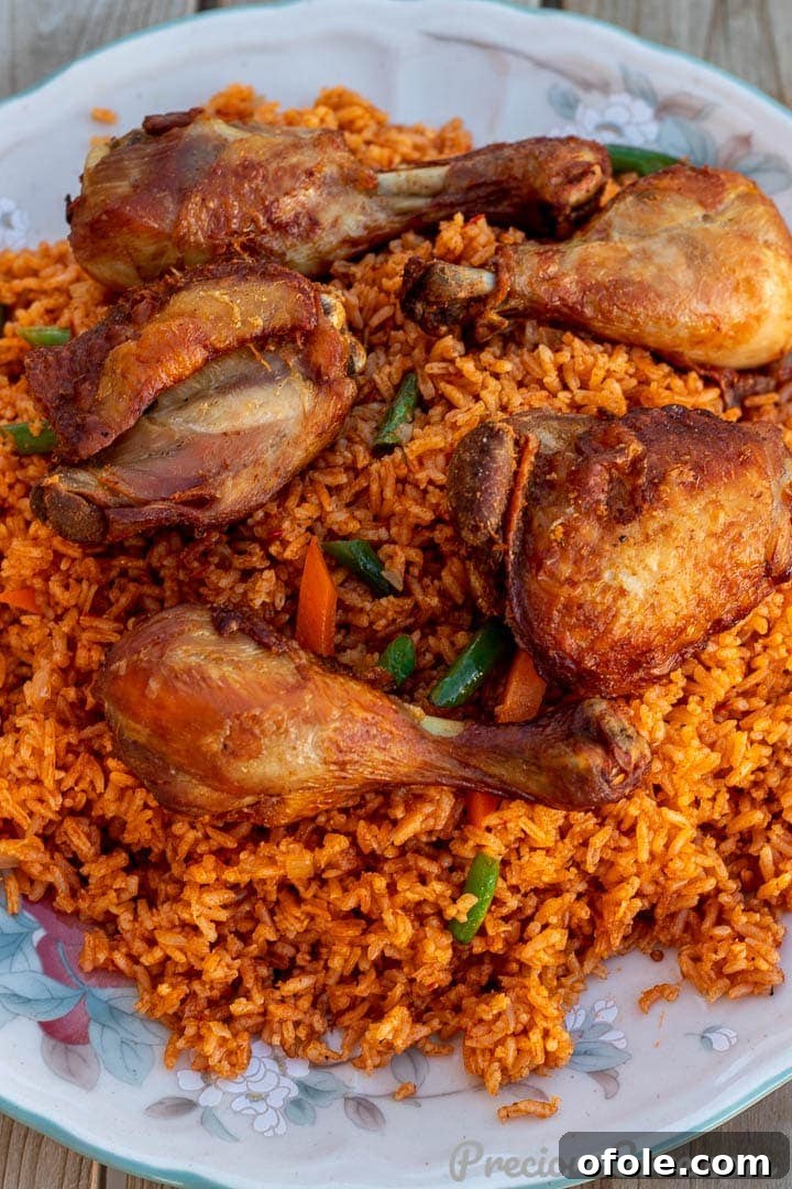 Discover Africa: 20 Irresistible Dinner Recipes 12 Generous platter of Jollof Rice with crispy cooked chicken thighs and drumsticks, a classic West African dinner.