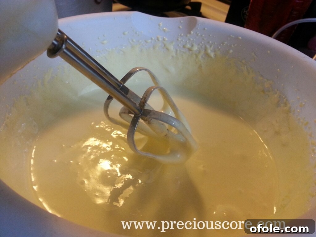Whisking egg yolks and sugar vigorously until light and fluffy
