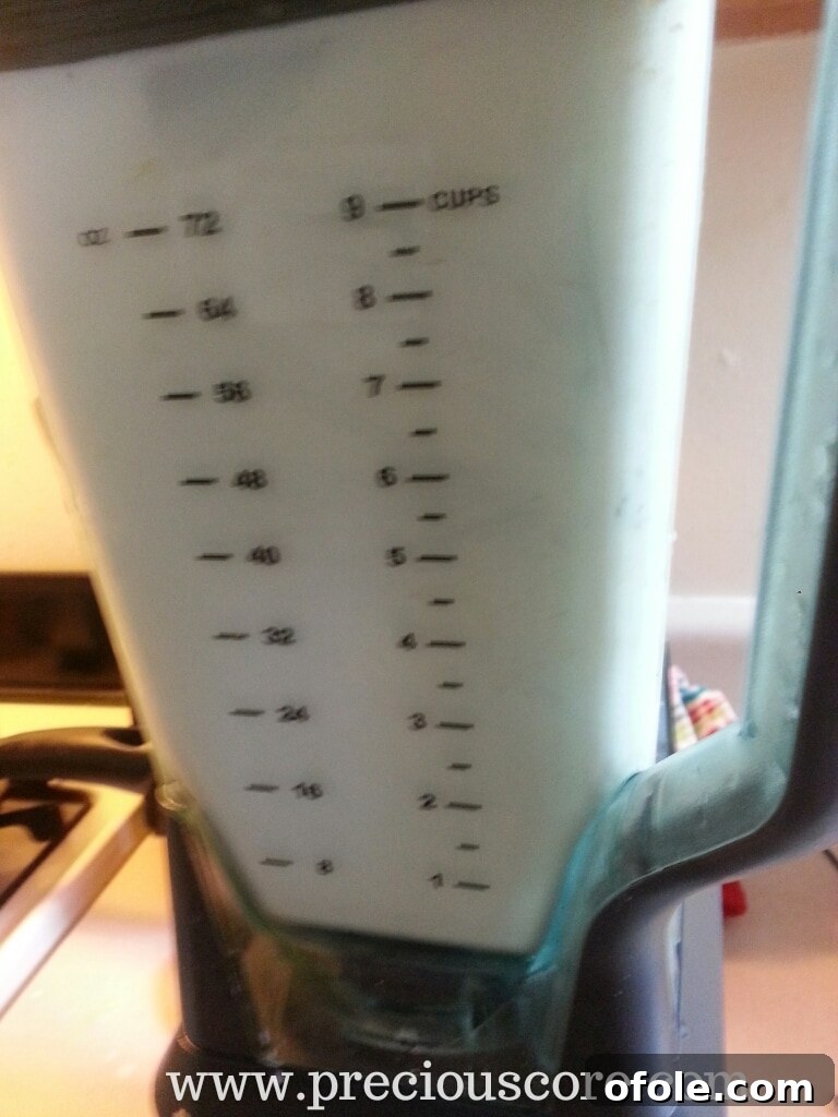Hot mint-infused dairy mixture being blended to incorporate mint leaves