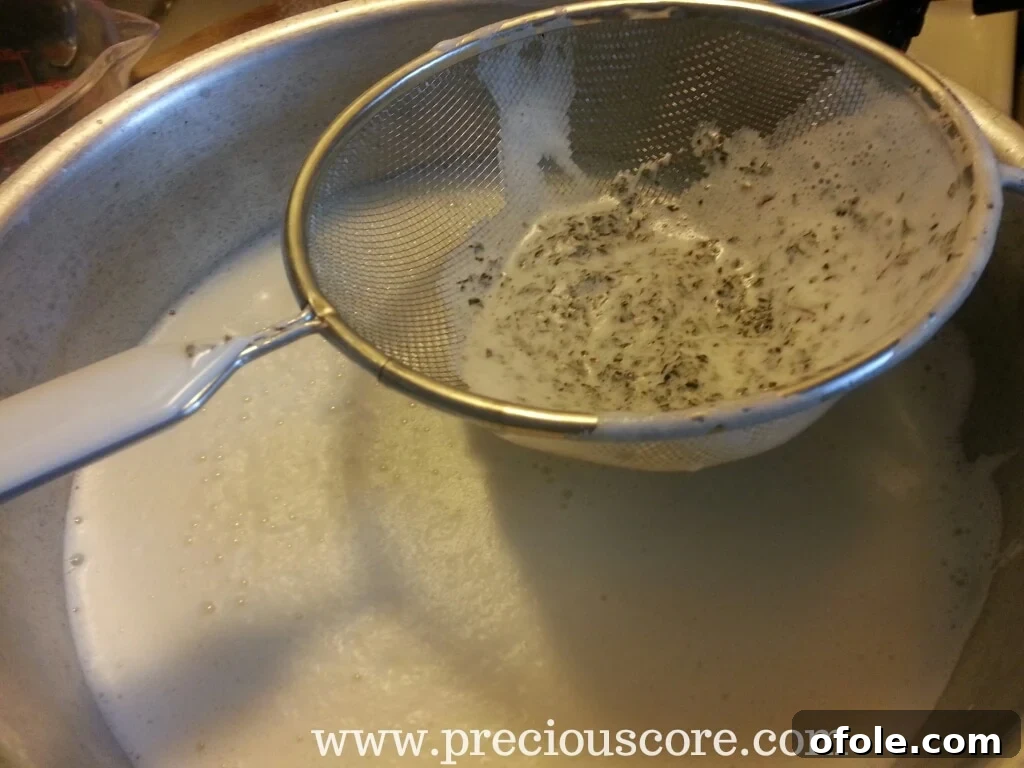 Straining blended mint-infused dairy back into a pot through a sieve