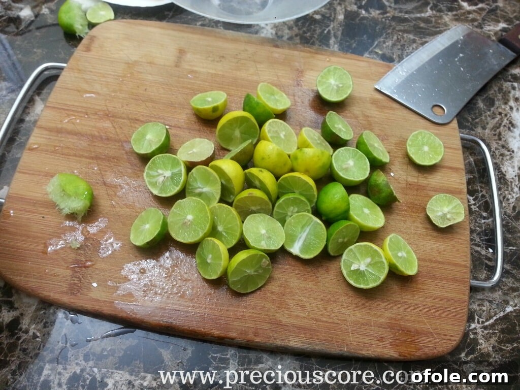 Key limes cut in half, arranged on a cutting board, ready for juicing