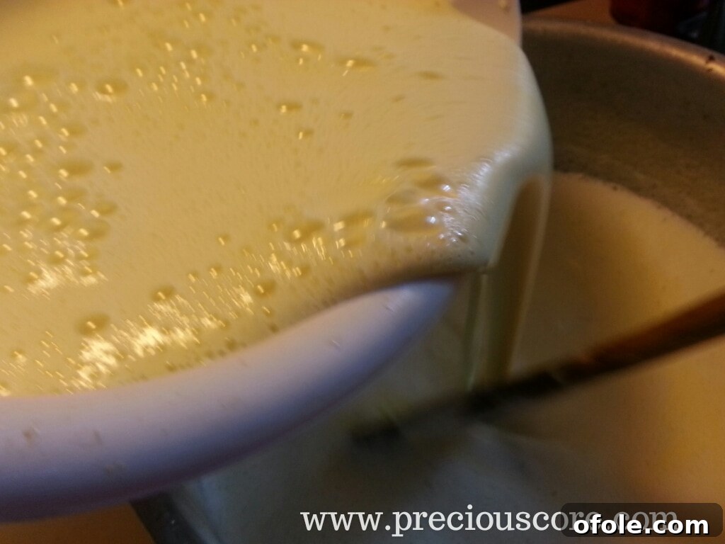 Pouring tempered egg mixture back into the pot with the dairy base