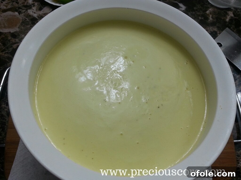 Pouring hot, cooked custard into a clean mixing bowl