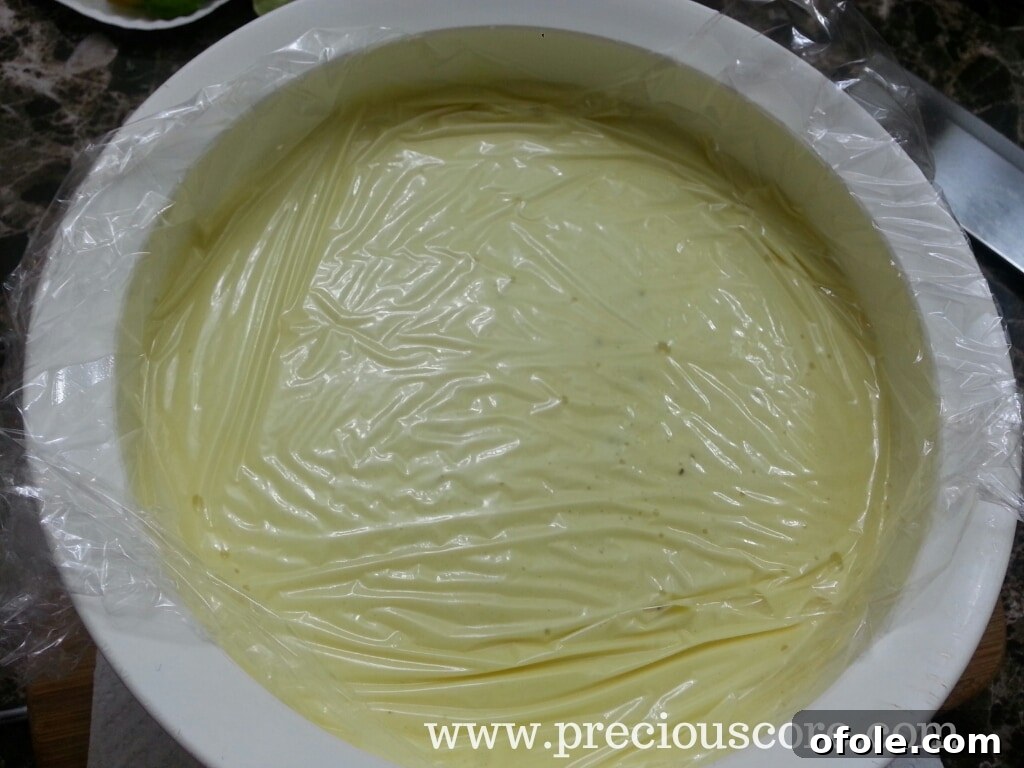 Custard covered with plastic wrap, touching the surface, chilling in fridge
