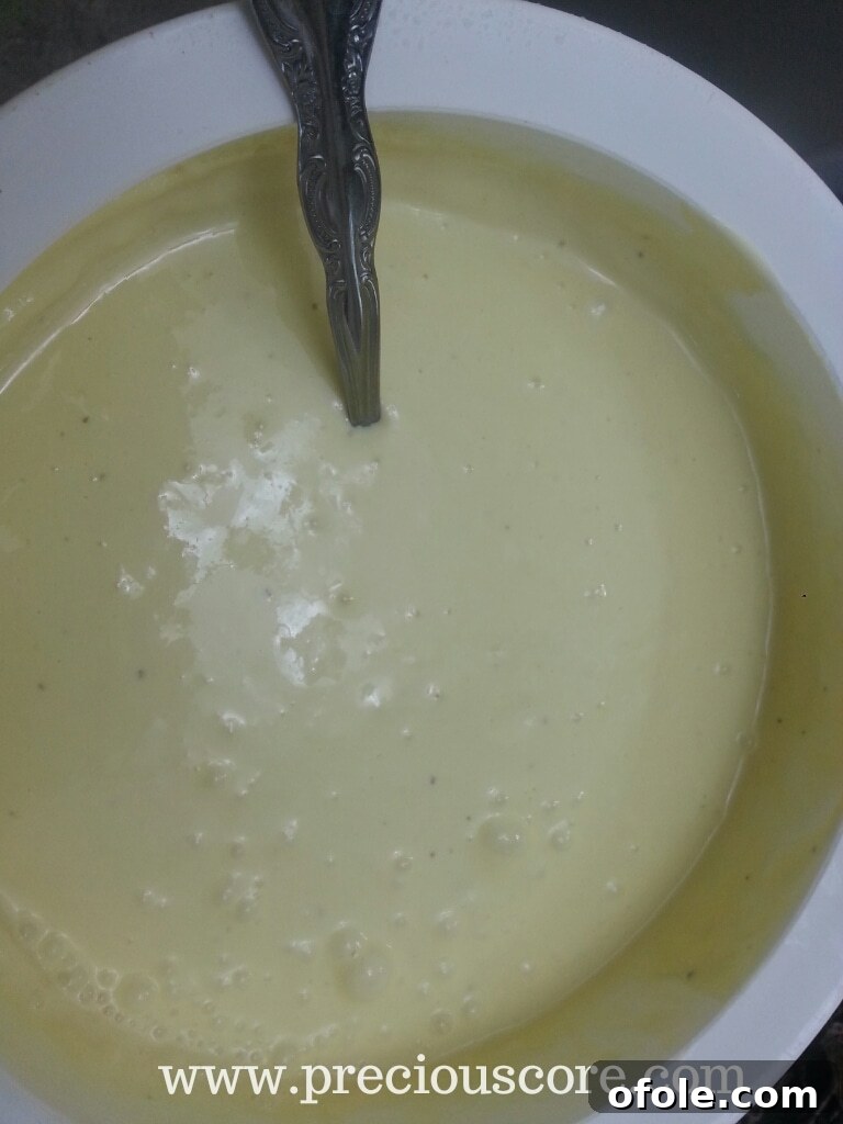 Whisking the chilled custard to prepare it for freezing