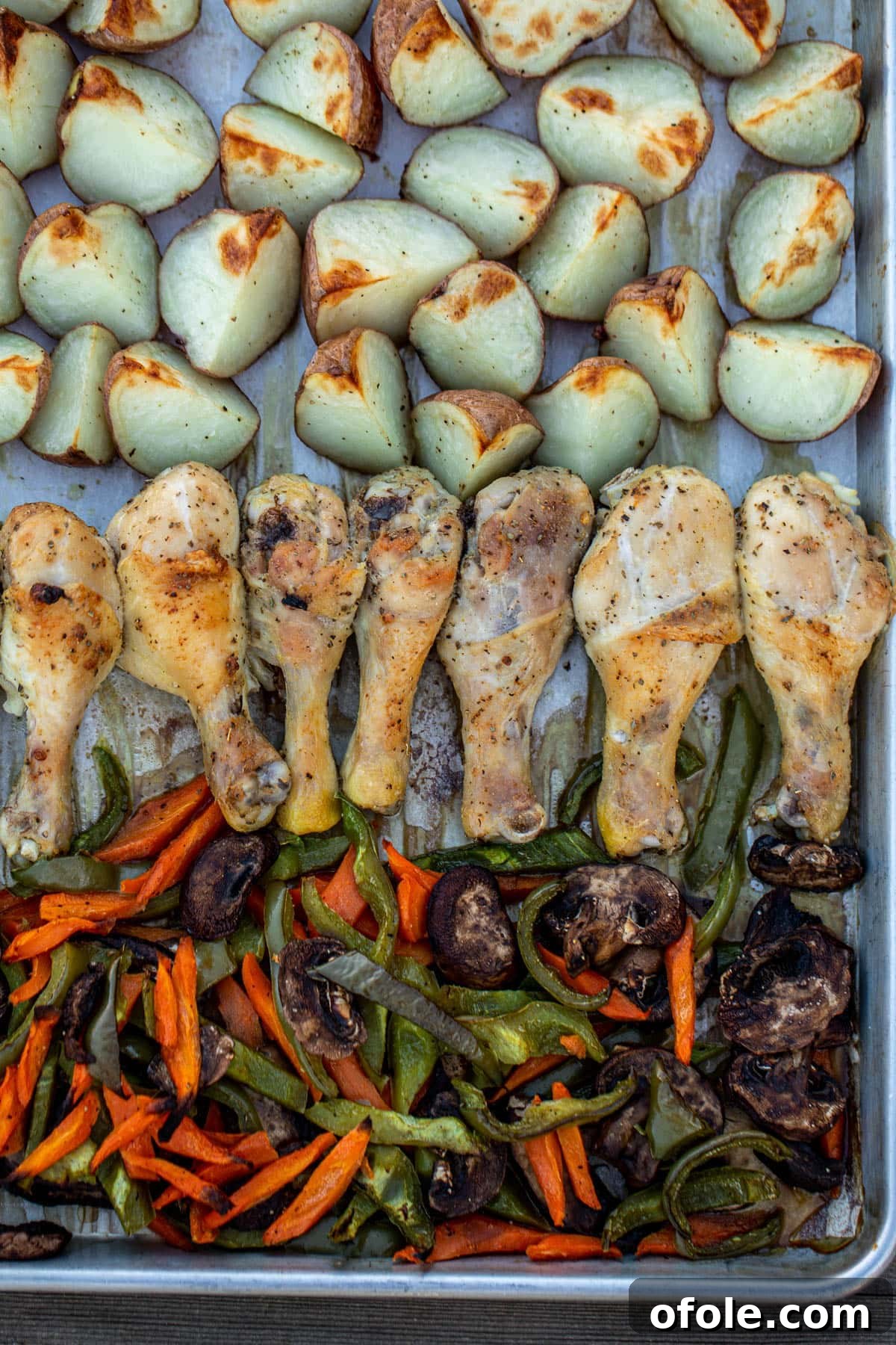 One-Pan Roasted Chicken, Potatoes, and Vegetables 2 Roasted chicken, potatoes and vibrant veggies artfully arranged on a single sheet pan, ready to be served.