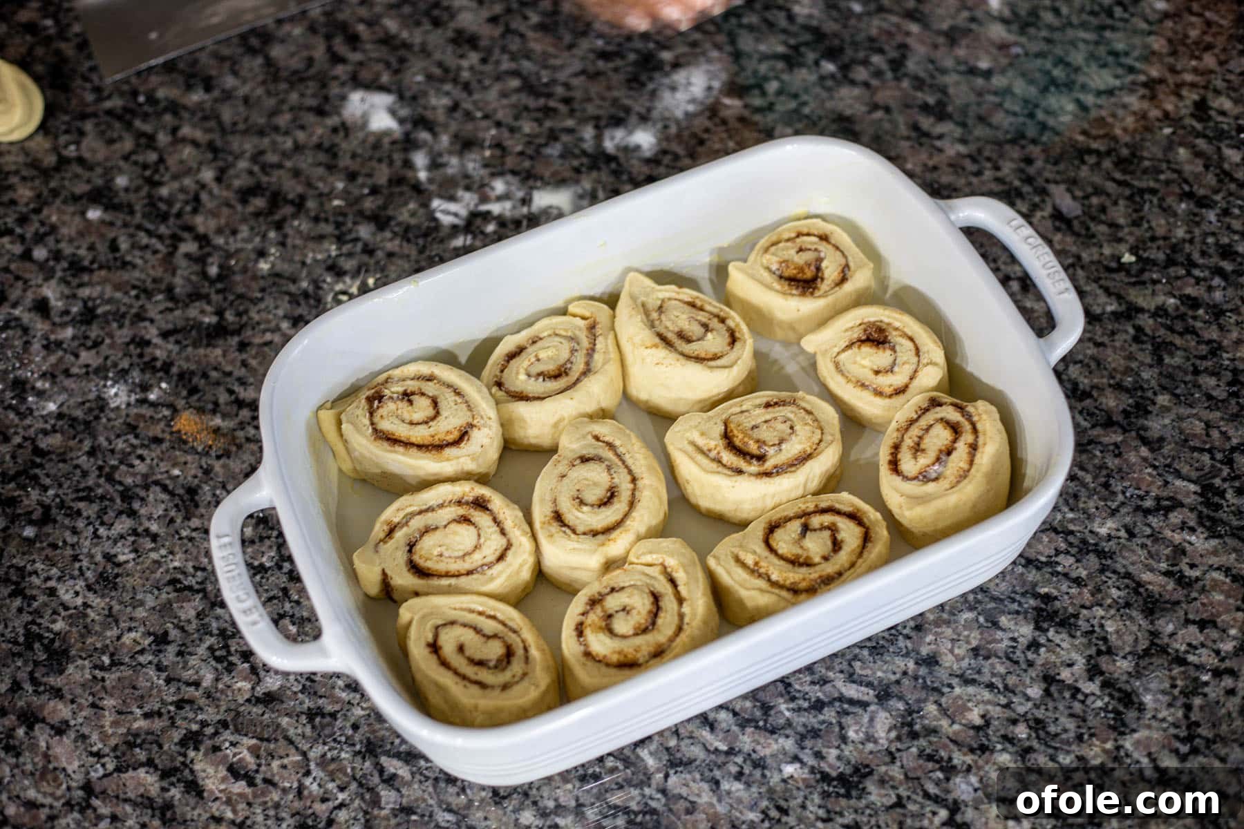 Heavenly Cinnamon Swirls with Tangy Cream Cheese Glaze 15 sweet spiced rolls in a white casserole pan