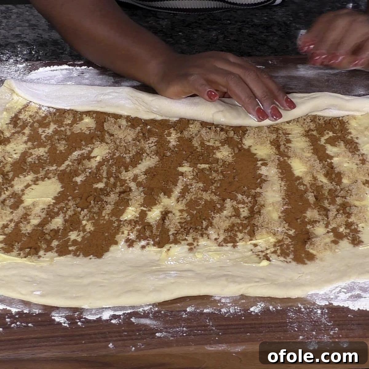 Heavenly Cinnamon Swirls with Tangy Cream Cheese Glaze 10 Hand rolling cinnamon roll dough into a log.