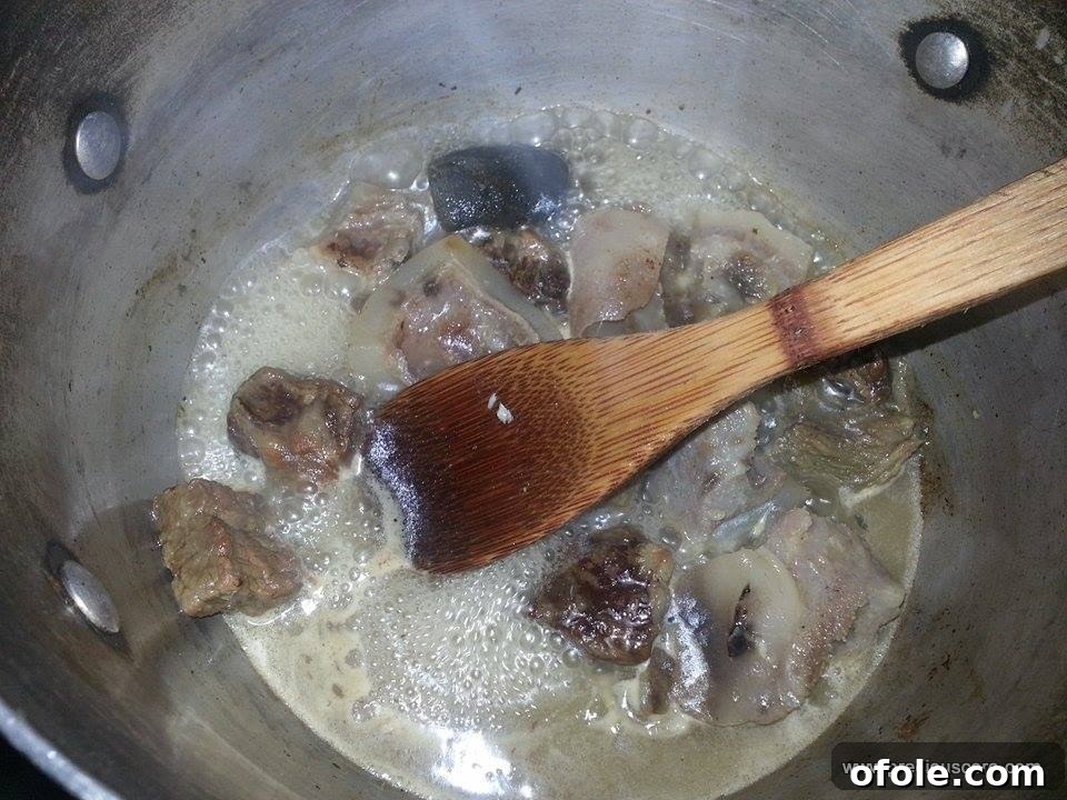 Unlock the Secrets of Delicious Okra Egusi Soup 4 Boiled beef and cow skin (canda) in rich stock, ready for soup preparation