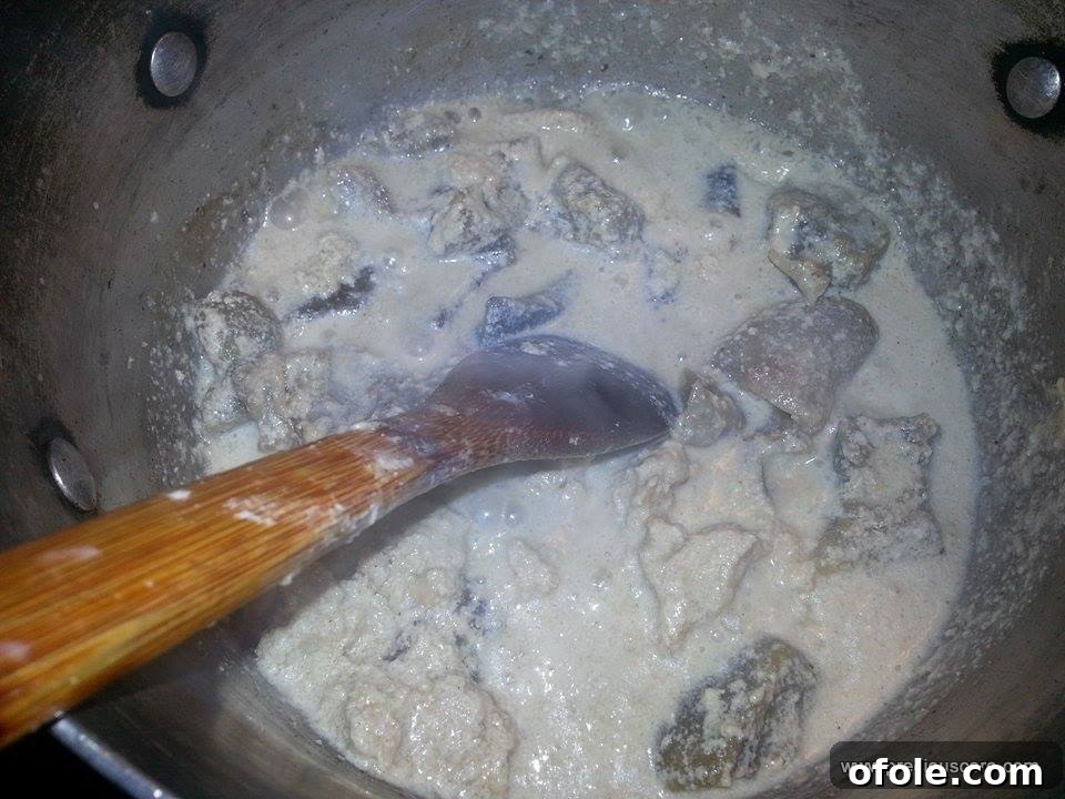 Unlock the Secrets of Delicious Okra Egusi Soup 5 Egusi paste simmering in the rich meat stock, beginning to thicken the soup