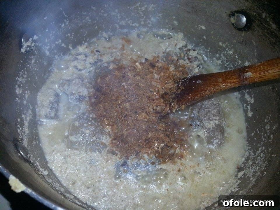 Unlock the Secrets of Delicious Okra Egusi Soup 6 Ground crayfish being stirred into the egusi soup for enhanced flavor