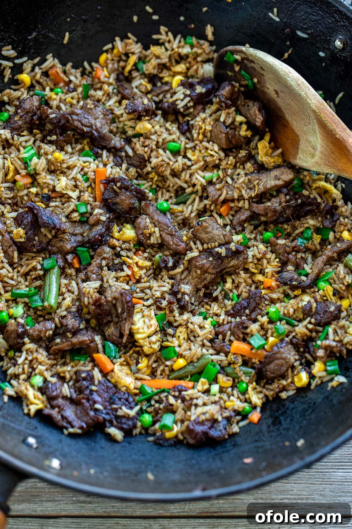 Gourmet Steak Fried Rice 4 A black wok filled with sizzling, perfectly cooked steak fried rice.