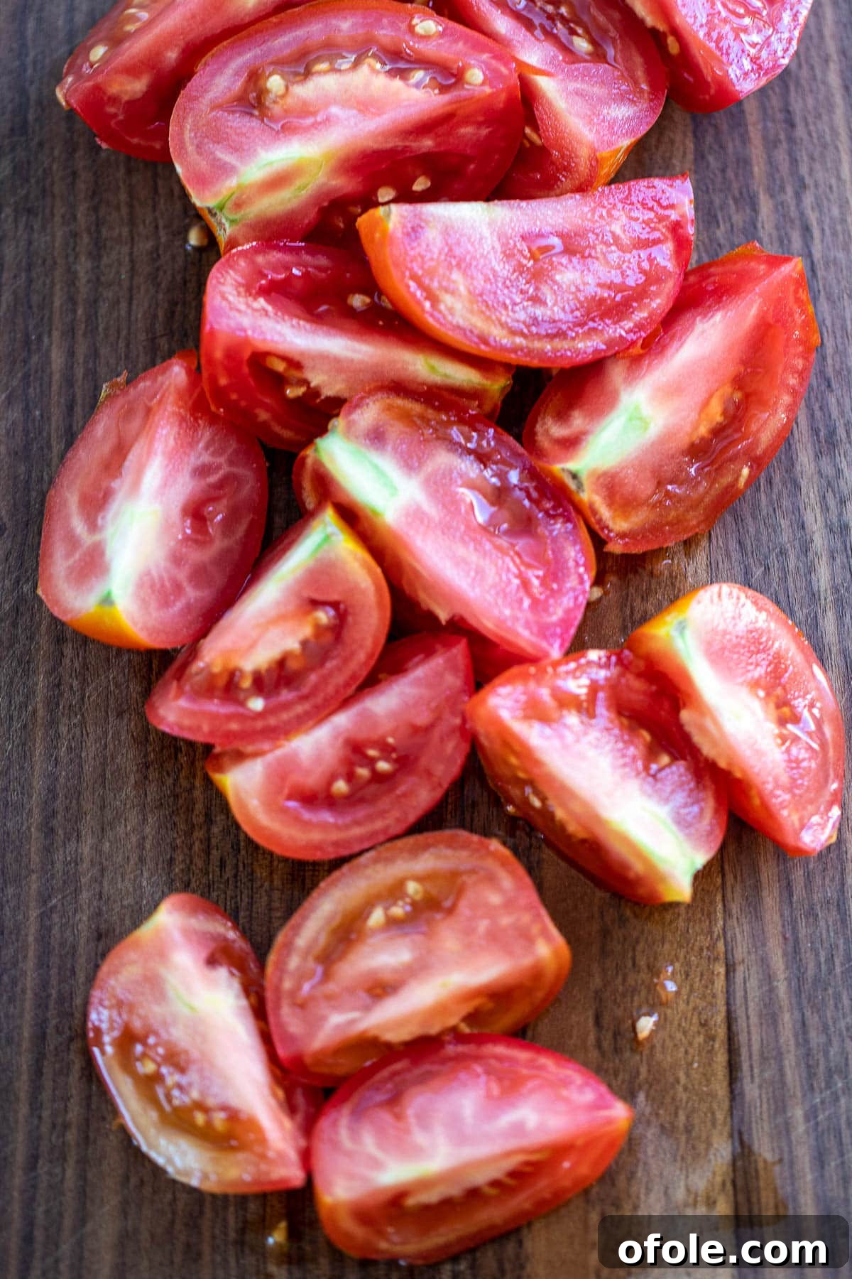 Slow-Simmered Homemade Tomato Paste 5 Quartered tomatoes neatly arranged on a chopping board, ready for blending.