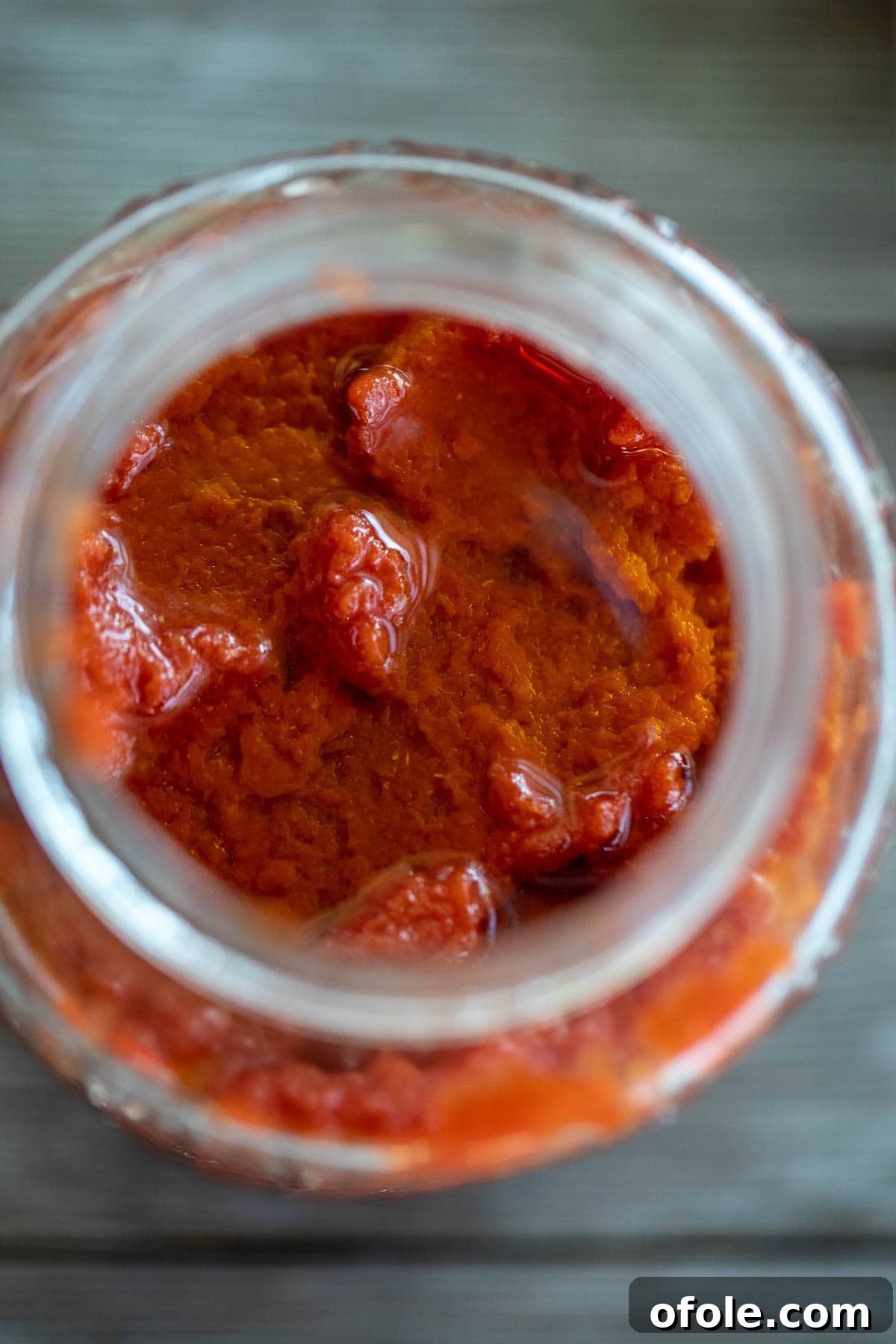 Slow-Simmered Homemade Tomato Paste 10 Homemade Tomato Paste stored in a mason jar, topped with a layer of olive oil.