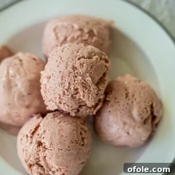 Scoops of no churn strawberry ice cream on a plate