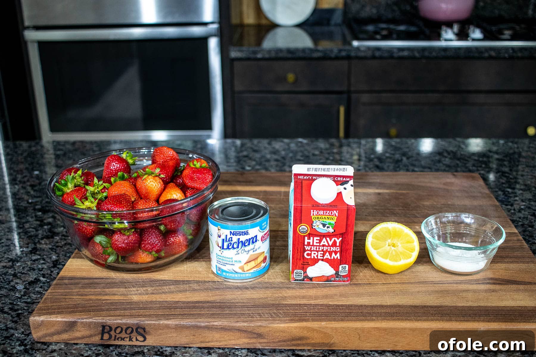 Easy No Churn Strawberry Ice Cream 4 Fresh strawberries, sugar, and lemon on a chopping board, ready for the ice cream recipe
