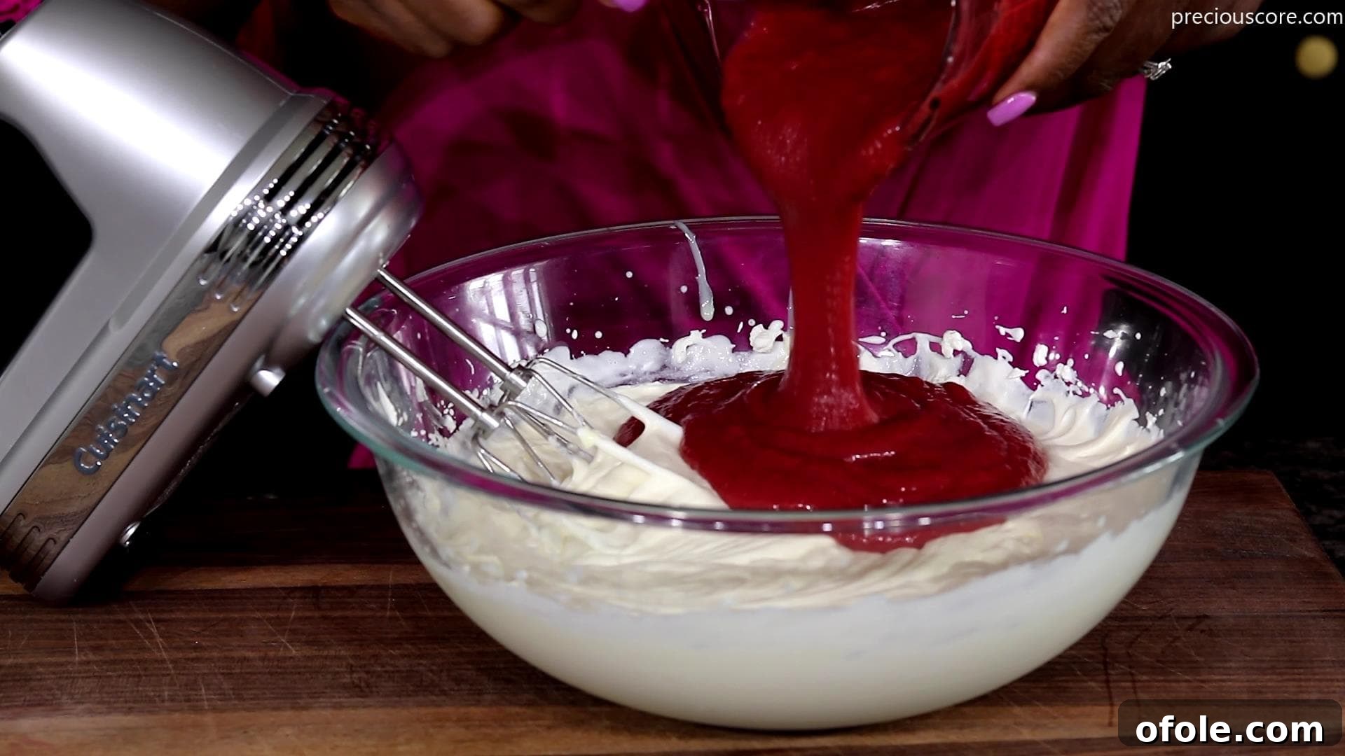 The chilled strawberry puree being gently folded into the whipped cream and condensed milk mixture.