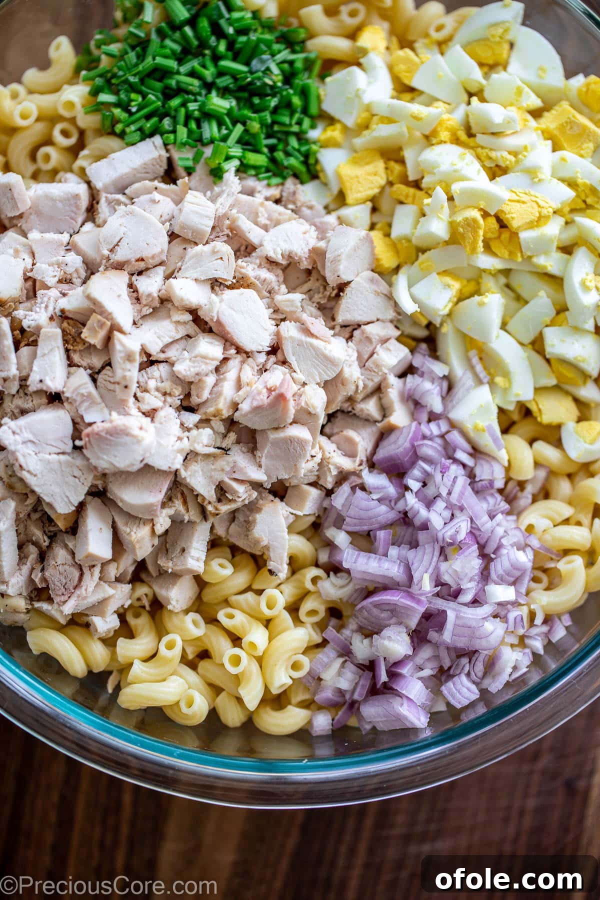 Creamy Chicken Pasta Delight 5 All ingredients for macaroni chicken salad in a large bowl, ready for dressing.