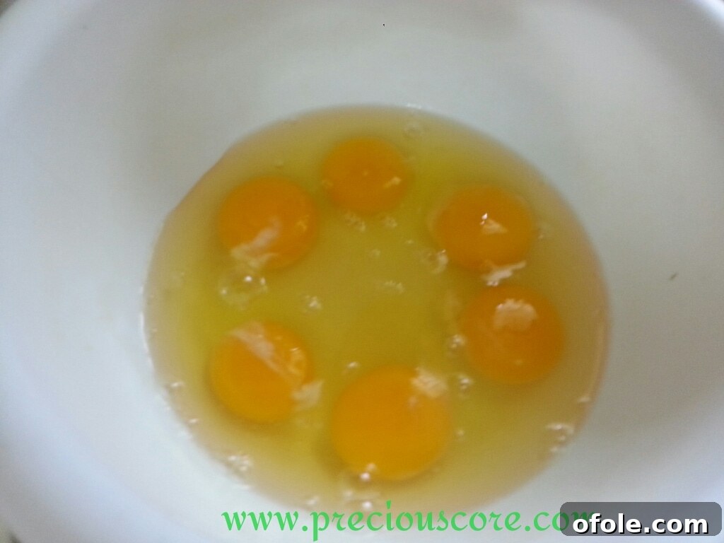 Unlock the Secret to Perfect Egg Cake 5 Cracked eggs in a mixing bowl, ready for preparation